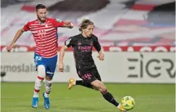  ?? (AFP) ?? Granada’s Portuguese defender Domingos Duarte (left) vies for the ball with Real Madrid’s Croatian midfielder Luka Modric in the La Liga on Thursday night.
