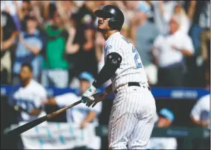  ?? The Associated Press ?? GOING, GOING, GONE: Colorado Rockies’ Nolan Arenado follows the flight of his three-run, home run of San Francisco Giants relief pitcher Mark Melancon in the ninth inning Sunday in Denver. The Rockies won 7-5.