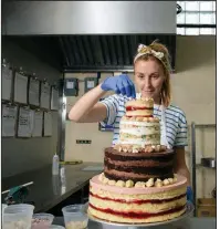  ?? The New York Times/CAITLIN OCHS ?? Christina Tosi completes one of her multiflavo­r tiered cakes at Milk Bar on June 8, in Brooklyn.