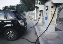  ?? GREG BAKER/AFP-GETTY IMAGES ?? Electric-vehicle recharging stations are being built in locations around the world, but David Booth says the numbers just don’t add up — either in terms of power supply or cost — to suggest we can ever support a world where every vehicle runs on...