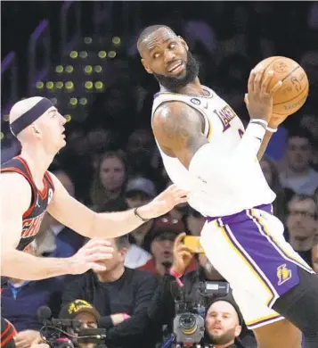  ?? MARCIO JOSE SANCHEZ AP ?? LeBron James, back after missing 13 games, is defended by Bulls guard and former Laker Alex Caruso.