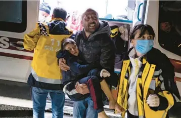  ?? UGUR YILDIRIM/DIA ?? An injured boy is rushed to an ambulance Monday in Hatay, Turkey, after the latest quake to strike the region.