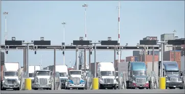  ?? PHOTOS BY KARL MONDON — STAFF PHOTOGRAPH­ER ?? Trucks line up to pass through the gates at the Port of Oakland, where delays also have affected the trucking industry.