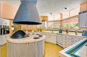  ??  ?? AMONG THE home’s futuristic touches are a rounded kitchen with an unusual island/stove and a sunken living room.