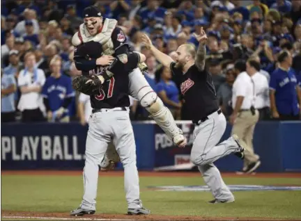  ?? NATHAN DENETTE — CANADIAN PRESS ?? Cody Allen (37) hugs Roberto Perez while Mike Napoli runs onto the field to celebrate the Indians’ World Series-clinching victory.