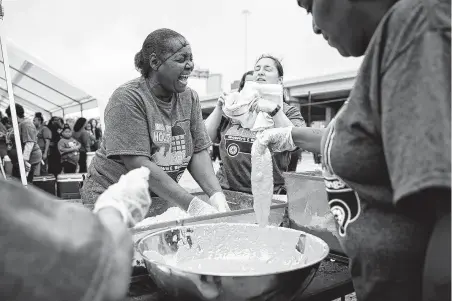  ?? Photos by Annie Mulligan / Contributo­r ?? Volunteer Stacie Young laughs as she helps batter fish during the fifth annual Hope for Houston Showers & Blessings for the Homeless Community event. Young is a member of New Hope Missionary Baptist Church in Houston.