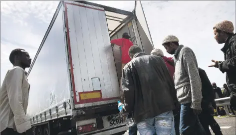  ??  ?? Migrants in Calais climb into a UK-bound truck, hoping to smuggle themselves across the Channel to claim asylum here