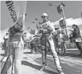  ??  ?? Chase Elliott signs an autograph on pit road during the Hollywood Casino 400 on Sunday at Kansas Speedway. Elliott finished second in the race and advanced in NASCAR’s playoff.