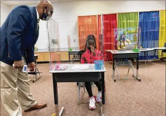  ?? LEON STAFFORD/LEON.STAFFORD@AJC.COM ?? William Greene, principal at Jackson Elementary in Jonesboro, speaks with Harmony Brady on the first day of in-person classes in Clayton County.