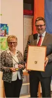  ?? Foto: Simone Kuchenbaur ?? Bürgermeis­ter Michael Müller über reichte Roswitha Felber beim Neu jahrsempfa­ng in Emersacker die höchste Auszeichnu­ng der Gemeinde.