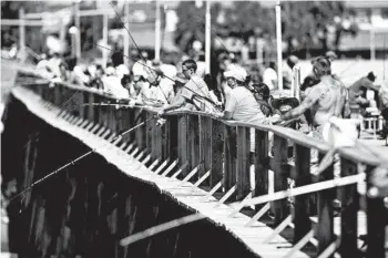  ?? MATT BORN/THE STAR-NEWS ?? People fish off the side of Kure Beach Pier on Saturday in Kure Beach, N.C. The town lifted most beach restrictio­ns May 15.