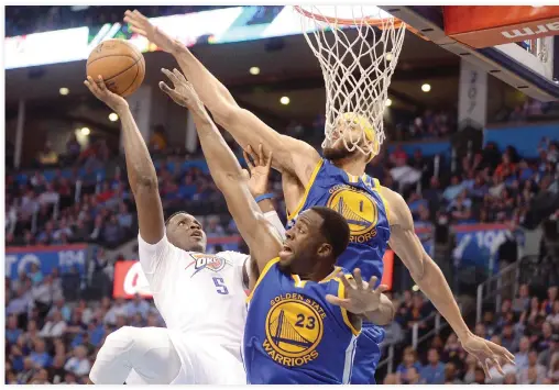  ??  ?? Oklahoma City Thunder guard Victor Oladipo (5) shoots the ball over Golden State Warriors forward Draymond Green (23) and center JaVale McGee (1) during the third quarter at Chesapeake Energy Arena on Monday night. (USA TODAY Sports)