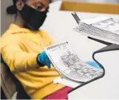  ?? JOHN LOCHER AP ?? A Nevada election worker scans mail-in ballots in Las Vegas last month.