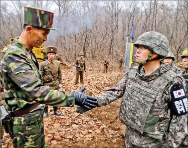  ?? SOUTH KOREAN DEFENCE MINISTRY/HANDOUT VIA REUTERS ?? A South Korean military officer (R) and a North Korean military officer shake hands during an operation to reconnect a road across the Military Demarcatio­n Line inside the Demilitari­sed Zone (DMZ) separating the two Koreas on Thursday, 22 November.