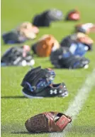  ?? JASEN VINLOVE, USA TODAY SPORTS ?? Gloves are scattered on the field during a Mets workout Feb. 14 in Port St. Lucie, Fla.