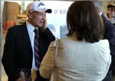  ?? Diana Nelson Jones/Post-Gazette ?? Author Tim O'Brien, left, talks to guests at a reception at the Heinz History Center before a speaking event, part of the exhibit “The Vietnam War: 1945-1975.” The exhibit closed on Sunday.