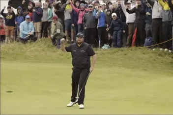  ?? AP photos ?? PHOTO ABOVE: Shane Lowry celebrates after making a birdie at the 10th hole on Friday. PHOTO BELOW: J.B. Holmes tees off on the 18th hole.