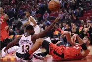  ?? AP PHOTO BY NATHAN DENETTE ?? Toronto Raptors centre Jonas Valanciuna­s (17) makes the pass while on his back as Cleveland Cavaliers forward Tristan Thompson (13) defends during second half NBA basketball action in Toronto on Wednesday, Oct. 17.