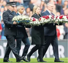  ??  ?? The wreaths are carried on to the Wembley pitch yesterday