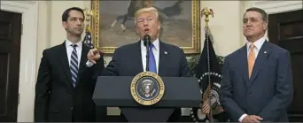  ?? Evan Vucci/Associated Press ?? President Donald Trump, flanked by Sen. Tom Cotton, R- Ark., left, and Sen. David Perdue, R-Ga., speaks at the White House on Wednesday.