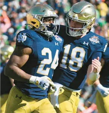  ?? SAM WASSON/GETTY ?? Notre Dame running back Jadarian Price (24) and quarterbac­k Steve Angeli celebrate after the Irish scored a touchdown against Oregon State during the first half of the Sun Bowl on Friday at Sun Bowl Stadium in El Paso, Texas.