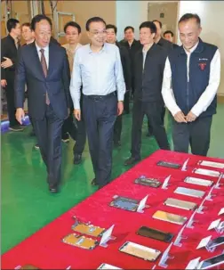  ?? WU ZHIYI / CHINA DAILY ?? Premier Li Keqiang inspects a Foxconn Technology Group plant in Zhengzhou, Henan province, accompanie­d by Terry Guo, founder and chairman of the company (left), on Tuesday.