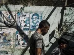  ??  ?? Ibrahim Al-Qassim walks past a poster of late Palestinia­n leader Yasser Arafat
