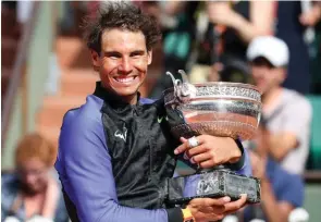  ?? – Reuters ?? ‘A LITTLE EMOTIONAL’: Spain’s Rafael Nadal celebrates with the trophy after defeating Switzerlan­d’s Stan Wawrinka in the final of the French Open at Roland Garros in Paris on Sunday.