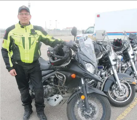  ?? DEAN PILLING ?? Cst. Phil Anderson stands beside a Suzuki V-Strom 650 motorcycle that the Calgary Police Service began test driving last year to see how they fit in the service’s existing motor pool. The city’s traffic unit will be rolling out an additional six new...