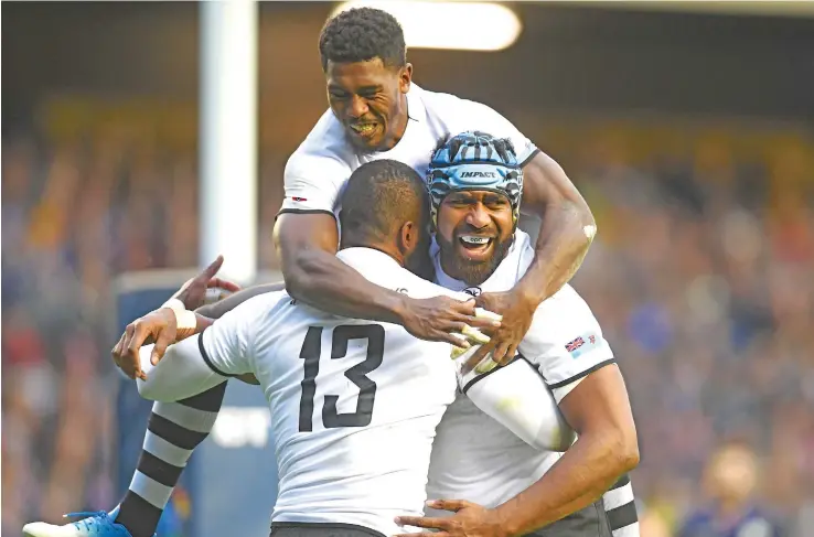  ?? Photo: Ian Muir ?? Fiji Airways Flying Fijians Frank Lomani and Tevita Cavubati (head gear) celebrate with Semi Radradra (13) after scoring a try against Scotland at Murrayfiel­d Stadium in Edinburgh on November 10, 2018.