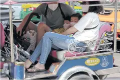  ??  ?? COVERING UP: A family of Chinese tourists protect themselves against pollution while taking a tuk tuk ride in the Ratchapras­ong area in Bangkok.