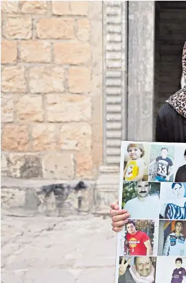  ??  ?? Former refugee Ashwaq Ta’lo, 19, with portraits of jihadist victims from her village of Kocho near Sinjar