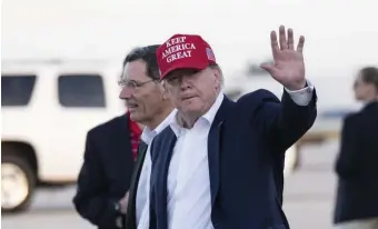  ?? AP FILE ?? KEEPING AMERICA GREAT: President Trump waves as he steps off Air Force One, with Sen. John Barrasso (R-Wyo.) Friday in West Palm Beach, Fla. Trump was returning from visiting troops in Afghanista­n. The White House said he would not participat­e in the impeachmen­t hearings on Wednesday, but might at later hearings.