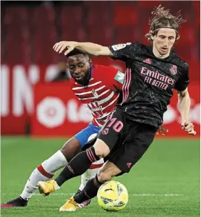  ?? — AP ?? In a tussle: real Madrid’s Luka Modric (right) vying for the ball with Granada’s yan Eteki during the La Liga match.