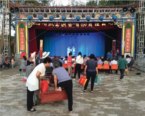  ?? (Sue-Lin Wong/Reuters) ?? VILLAGERS WATCH a local opera in Bianqiang village in northweste­rn China earlier this year. This summer’s event was different because more young parents were present. In previous years they had left their children in the care of grandparen­ts while they...