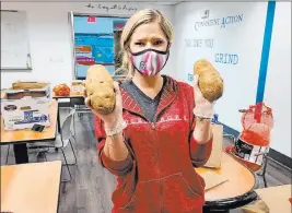  ?? Findlay ?? Findlay Volkswagen Henderson Marketing Director Marcy Colletti holds potatoes at the dealership pantry in the Valley Automall.