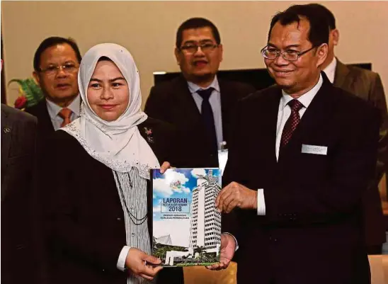  ?? BERNAMA PIC ?? Auditor General Datuk Nik Azman Nik Abdul Majid (right) and Public Accounts Committee chairman Datuk Noraini Ahmad with the Auditor General’s Report 2018 at Parliament in Kuala Lumpur yesterday.