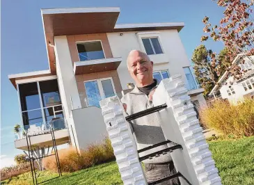  ?? Arnold Gold/Hearst Connecticu­t Media ?? Architect Leigh Overland is photograph­ed outside of his home on Shoreham Terrace in Fairfield on Oct. 31, with a section of an insulated concrete form used in the building of the exterior walls of his home.