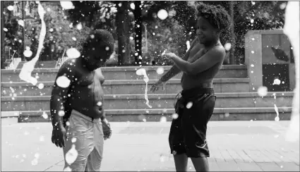  ?? PHOTO/ANDREA SMITH ?? Kai Frazier and Chance Seawright, brothers visiting from Aiken, South Carolina, cool off in the Fountain of Rings in Centennial Olympic Park, on Monday, in Atlanta. AP