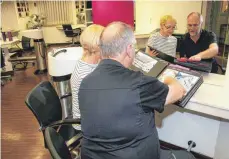  ?? FOTO: SABINE ZIEGLER ?? Sybille und Franz Daiber blättern in Fotoalben mit der Chronik ihres Friseursal­ons und erzählen vom Wandel der Haarmode in den 70 Jahren seines Bestehens.