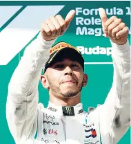  ??  ?? Mercedes driver Lewis Hamilton celebrates on the podium after winning the Hungarian Formula One Grand Prix at the Hungarorin­g racetrack in Mogyorod, northeast of Budapest, yesterday.