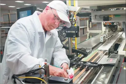  ?? HE XIANFENG / XINHUA ?? A Wanxiang Group worker assembles solar panels at a factory in Elgin, Illinois. Wangxiang Group is an auto parts manufactur­er and clean energy provider based in Hangzhou, Zhejiang province.