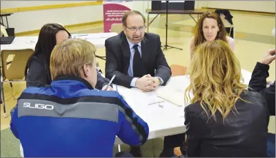  ?? NEWS PHOTO TIM KALINOWSKI ?? Medicine Hat Catholic Board of Education superinten­dent of schools Joe Colistro discusses new zoning for Ecole St. John Paul II School with concerned parents at an open house at Holy Family parish hall Wednesday night.