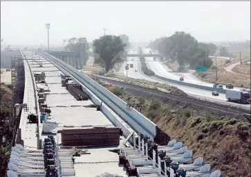  ?? Rich Pedroncell­i Associated Press ?? A HIGH-SPEED RAIL viaduct parallels Highway 99 near Fresno. When voters approved the rail project in 2008, they were told the entire system would be operating this year; the projected date is now 2033.