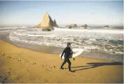  ??  ?? Surfer Jameson Kenway heads to Martins Beach in search of waves in October. Beach owner Khosla wants to cut off public access to the site.