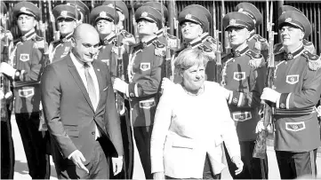  ??  ?? Merkel (right) walks with Georgian Prime Minister Mamuka Bakhtadze as she inspects the honour guard upon her arrival in Tbilisi. — AFP photo