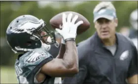  ?? MATT ROURKE — THE ASSOCIATED PRESS ?? The Eagles’ Darren Sproles catches a pass as coach Doug Pederson looks on during practice at NovaCare Complex recently. The team extended Sproles’ contract through the 2017season.