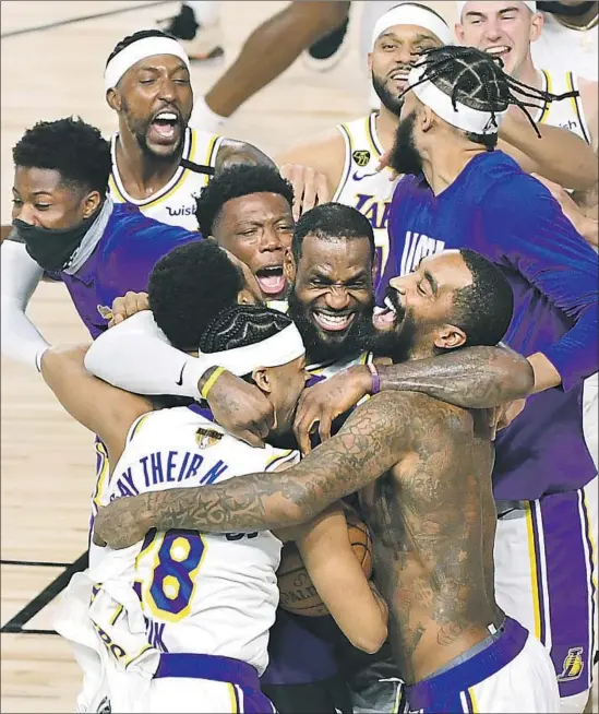  ?? Wally Skalij Los Angeles Times ?? L e BRON JAMES, center, and the Lakers go wild after winning the team’s 17th title, tying Boston for most. James won his fourth title, with a third different franchise.