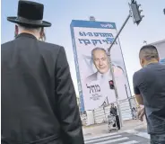  ?? ?? People walk past an election campaign billboard showing Benjamin Netanyahu, Bnei Brak, Israel, Oct. 25, 2022.