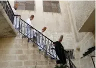  ??  ?? Sufi Dervish dancers of the Kharrat family descend a staircase at their home.